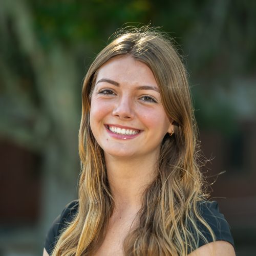 Madison Fulton wearing a black tee standing outside of Dickinson Hall and smiling for a headshot.