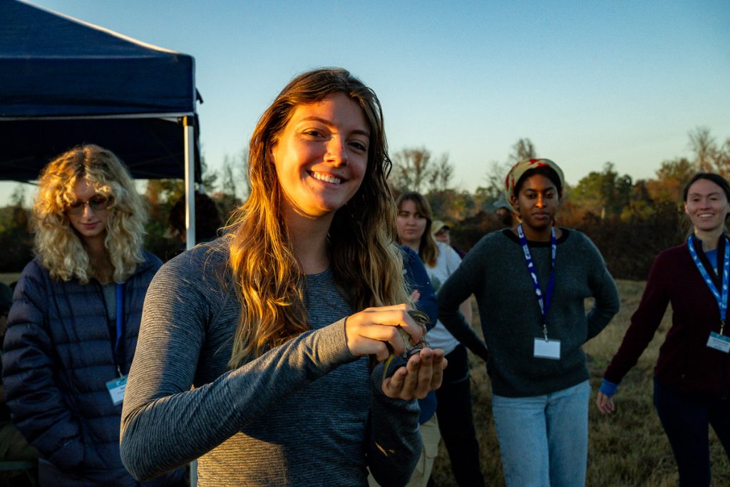 Madison smiles while holding a banded bird using bander's grip.