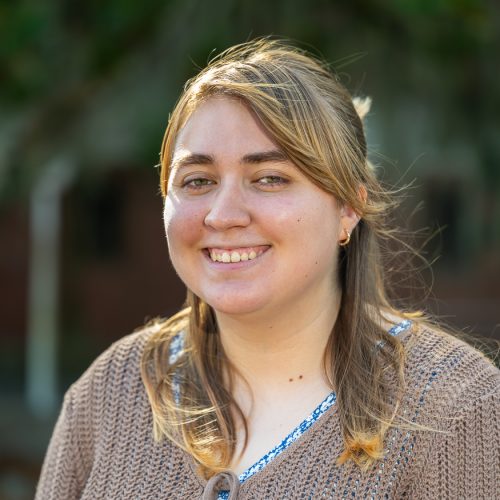 Sol Lima wearing a sweater standing outside of Dickinson Hall and smiling for a headshot.
